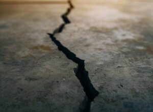 Cracks in a basement floor could be caused by shrinkage during the concrete curing process, differential settlement, or frost heave, if you live in a cold climate.